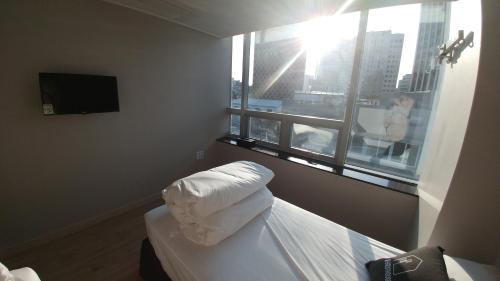 a bedroom with a bed and a window with a view at K-Guesthouse Dongdaemun Premium in Seoul