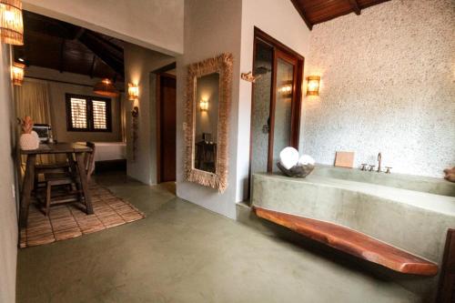 baño con bañera grande y mesa en Caraíva Villas de Jardel - Casa Principal, en Caraíva