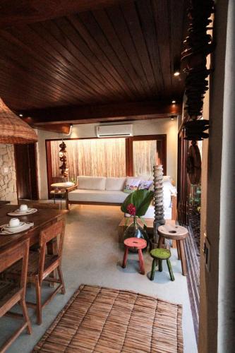 a living room with a couch and a table and chairs at Caraíva Villas de Jardel - Casa Principal in Caraíva