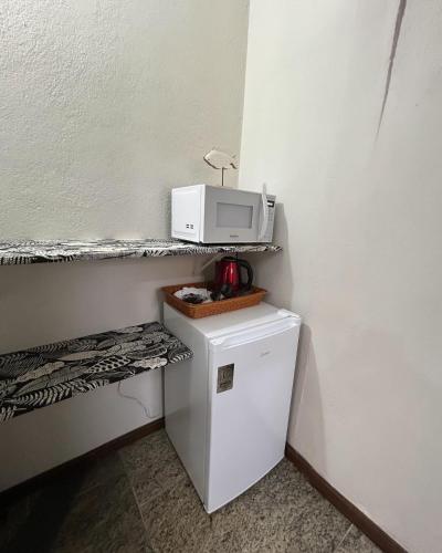 a microwave on top of a refrigerator in a room at Pousada Kembali Maresias in Maresias