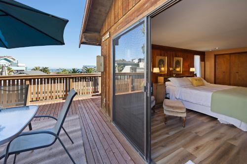 a bedroom with a bed and a balcony with a table and chairs at 221W 221 Whittley in Avalon