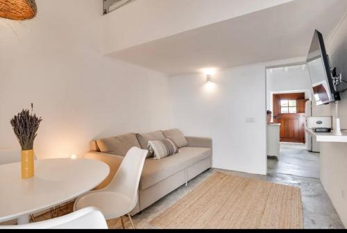 a white living room with a couch and a table at Casa Do Largo-Alqueva in Campinho