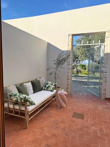 a couch sitting on a patio with an open door at Hotel Finca Olivar in Benissa