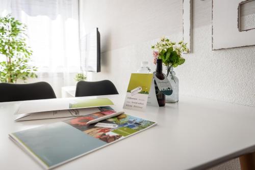 a table with a magazine and flowers on it at Deluxe Appartements am Münster in Freiburg im Breisgau