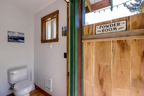 a bathroom with a toilet and a wooden door at Making lasting memories while enjoying this unique glamping experience in Maple Falls