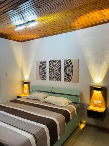 a bedroom with two beds and two lights on the wall at Blue Pearl Beach House in Sozopoli