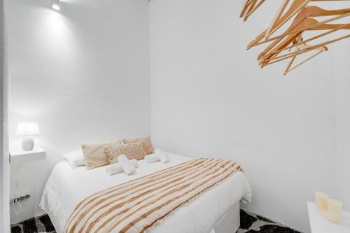 a white bedroom with a bed with a striped blanket at Casa da Junqueira-Alqueva in Campinho