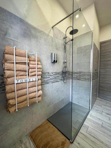 a bathroom with a shower and towels on a wall at Solema Lake Como in Bellano