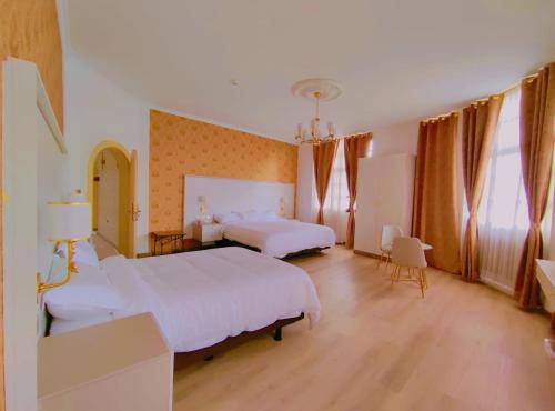 a large bedroom with two beds and two windows at Hotel Sucre in Quito