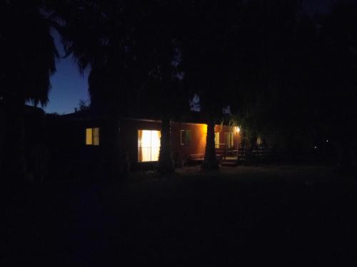 a house at night with a light in the window at Hostal Santa Elena in Isla de Maipo