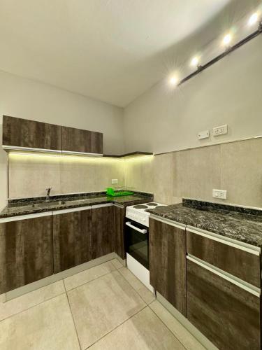 a kitchen with wooden cabinets and a stove top oven at Av Suites in Rosario