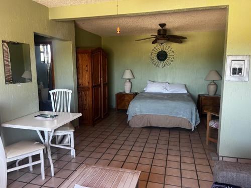 a bedroom with a bed and a table and a fan at Ocotillo del Mar in San Felipe