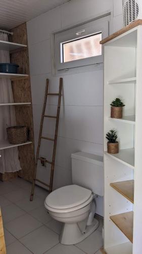 une salle de bain avec toilettes, une échelle et une fenêtre dans l'établissement Chalet vue mer, à Gruissan