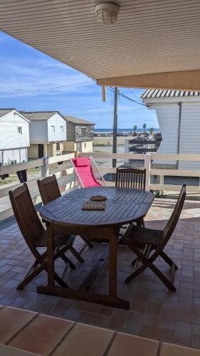 une table et des chaises en bois sur une terrasse dans l'établissement Chalet vue mer, à Gruissan