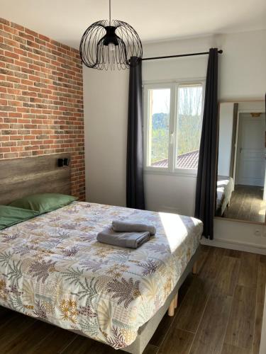 une chambre avec un lit et un mur de briques dans l'établissement Le N4 des Hauts de SARLAT, Clim Piscine Parking, à Sarlat-la-Canéda