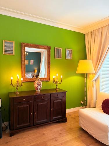 a green bedroom with a mirror and a bed at COMFORTABLE STYLISH ROOM in city centre of The Hague - HOME STAY in The Hague