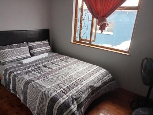 a bed in a bedroom with a window at ATHOME BELLVILLE Chrismar in Cape Town