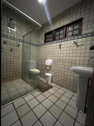 a bathroom with a shower and a toilet and a sink at House 061 in Maceió