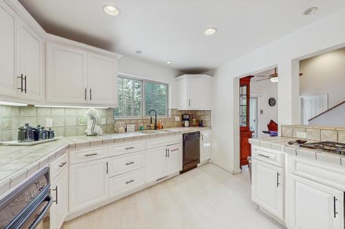 a large white kitchen with white cabinets and appliances at Skyline Serenity in South Lake Tahoe