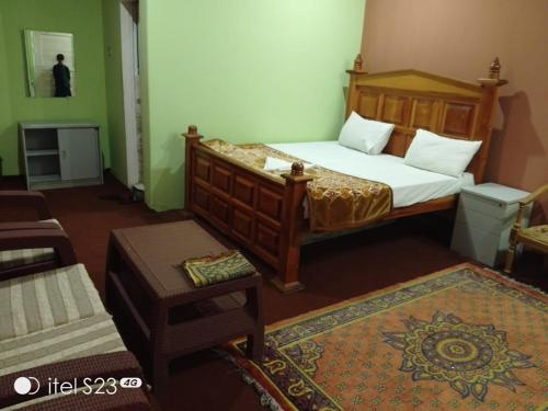 a bedroom with a bed and a chair and a table at Sky resort ajk patikka in Muzaffarabad