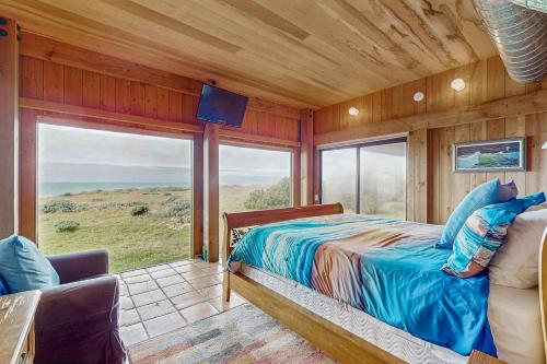 a bedroom with a bed and a large window at Compass Rose in Sea Ranch