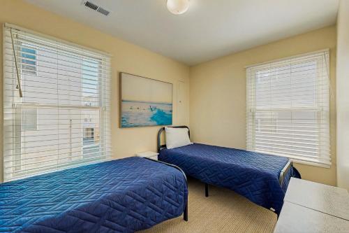 a bedroom with two beds and two windows at Rainbow Cove --- 117 Dagsworthy Ave #B in Dewey Beach
