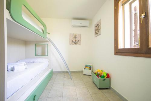 a hospital room with a bed and a window at Veranda with Jacuzzi & BBQ 1 minute from the Beach in Capo Comino