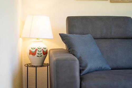 a lamp on a side table next to a couch at Veranda with Jacuzzi & BBQ 1 minute from the Beach in Capo Comino