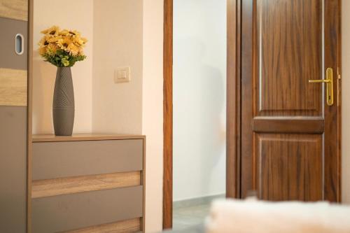 a vase of flowers on a shelf next to a door at Veranda with Jacuzzi & BBQ 1 minute from the Beach in Capo Comino