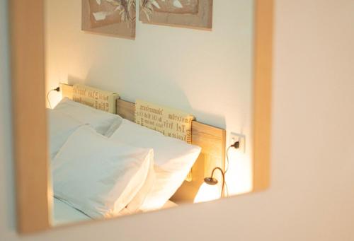 a mirror reflection of a bed in a room at Veranda with Jacuzzi & BBQ 1 minute from the Beach in Capo Comino