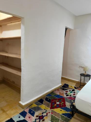 エルフードにあるAppartement hotel - Aura Palmeraieの白い壁の客室で、ベッド1台が備わります。