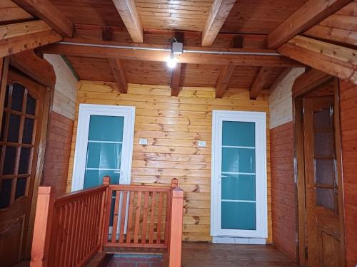 a wooden cabin with two windows and a balcony at Villa Tomorrow in Ujanik