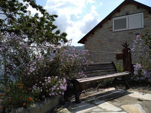 a wooden bench in front of a garden with flowers at Villa Tomorrow in Ujanik