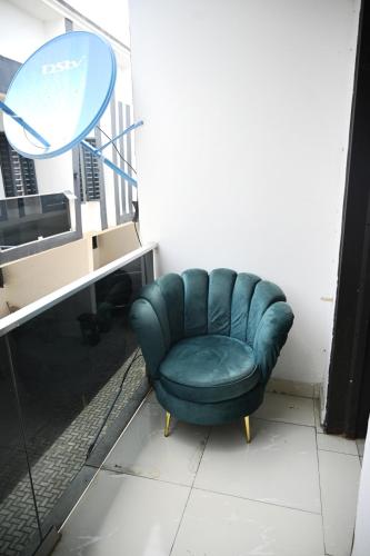 a green chair sitting in a room next to a desk at NEW LUXURY 3BED TERRACE DUPLEX APARTMENt in Lekki