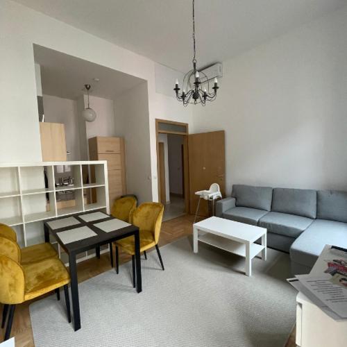 a living room with a couch and a table at Klikk Apartments at Gozsdu in Budapest