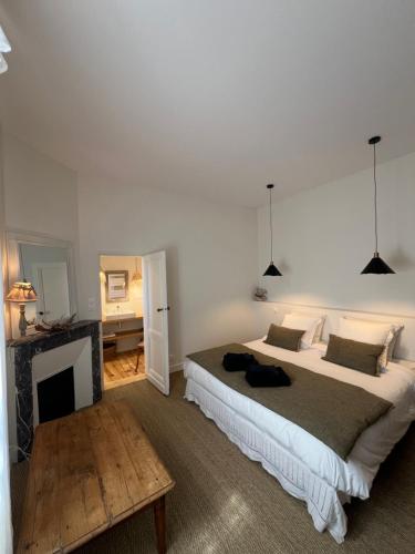 - une chambre avec un grand lit et une cheminée dans l'établissement Luxe et Charme - L'Alcôve - Plage à pieds - Meublé de tourisme 4 étoiles -, à Arcachon