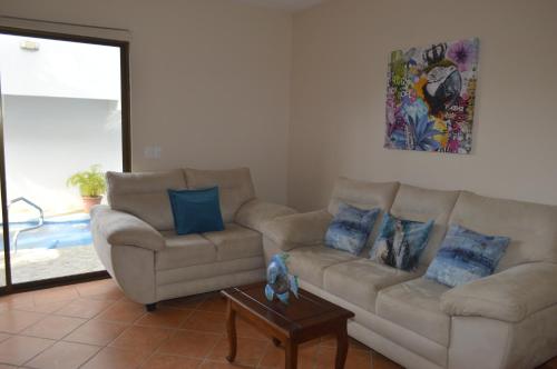 a living room with two couches and a table at Apartotel VILLA ALTA TAMARINDO in Tamarindo