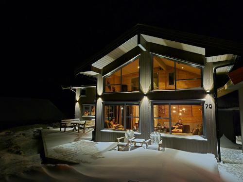 ein großes Haus im Schnee in der Nacht in der Unterkunft Large Modern Family Cottage in Lifjell