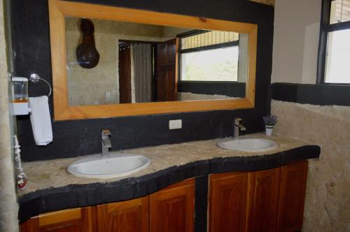 a bathroom with two sinks and a mirror at Apartotel VILLA ALTA TAMARINDO in Tamarindo