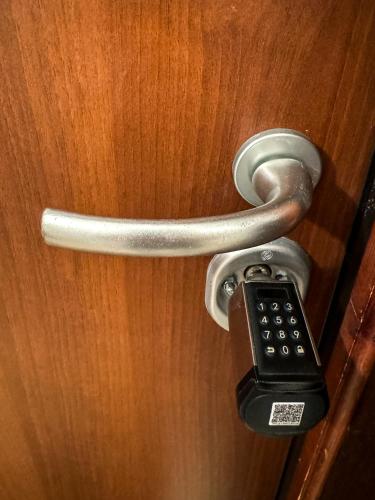 a doorhandle with a remote control on a wooden door at Solema Lake Como in Bellano