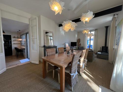 une salle à manger avec une table et des chaises en bois dans l'établissement Luxe et Charme - L'Alcôve - Plage à pieds - Meublé de tourisme 4 étoiles -, à Arcachon
