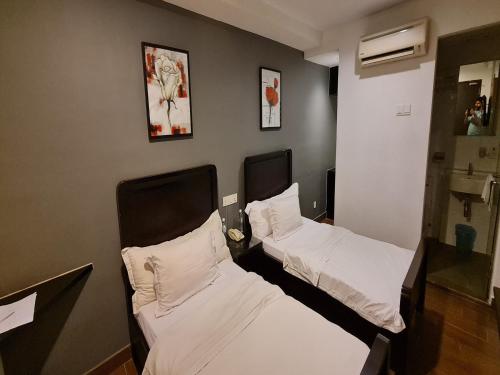 two beds in a room next to each other at Hotel O Crossroads Hotel in Kuala Lumpur