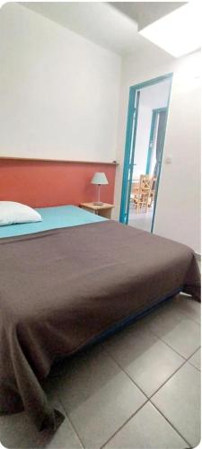 - une chambre avec un lit et une porte donnant sur un balcon dans l'établissement Bleu miami, à Argelès-sur-Mer
