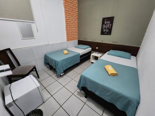 a room with two beds and a sign on the wall at Casa Recife Pousada in Recife