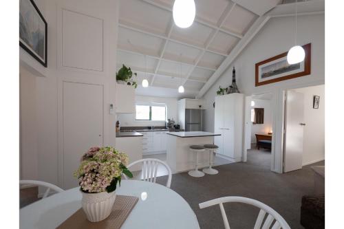 a kitchen and dining room with a white table and chairs at Tawa Retreat - Wellington Holiday Home in Wellington