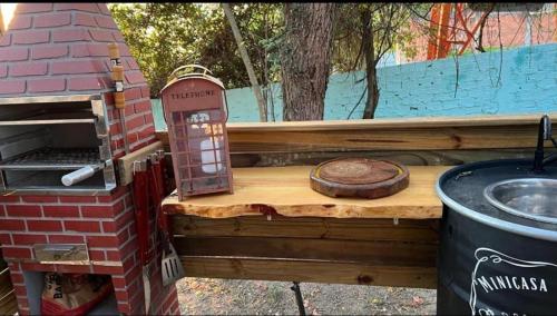 a gingerbread house with a grill and a wooden table at Minicasa Brasileira in Sorocaba