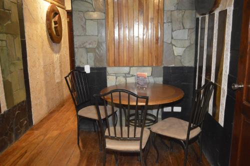a table and chairs in a room with a stone wall at Apartotel VILLA ALTA TAMARINDO in Tamarindo