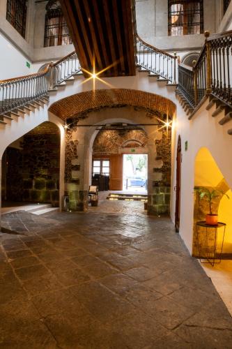 an empty hallway with stairs and a stone floor at Casa de la Luz Hotel Boutique in Mexico City
