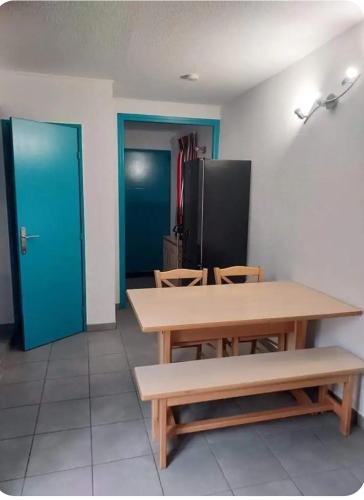une chambre avec une table, des chaises et une porte bleue dans l'établissement Bleu miami, à Argelès-sur-Mer