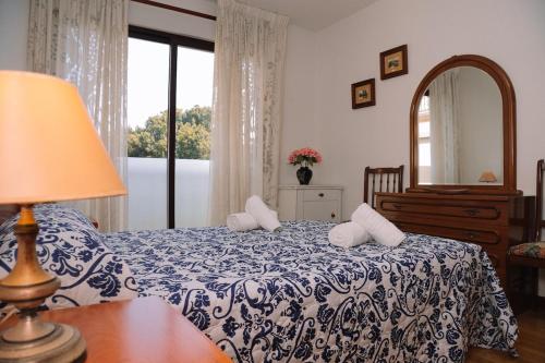 Un dormitorio con una cama azul y blanca con espejo en Económico y al lado del mar by CABANA Rentals, en Baiona